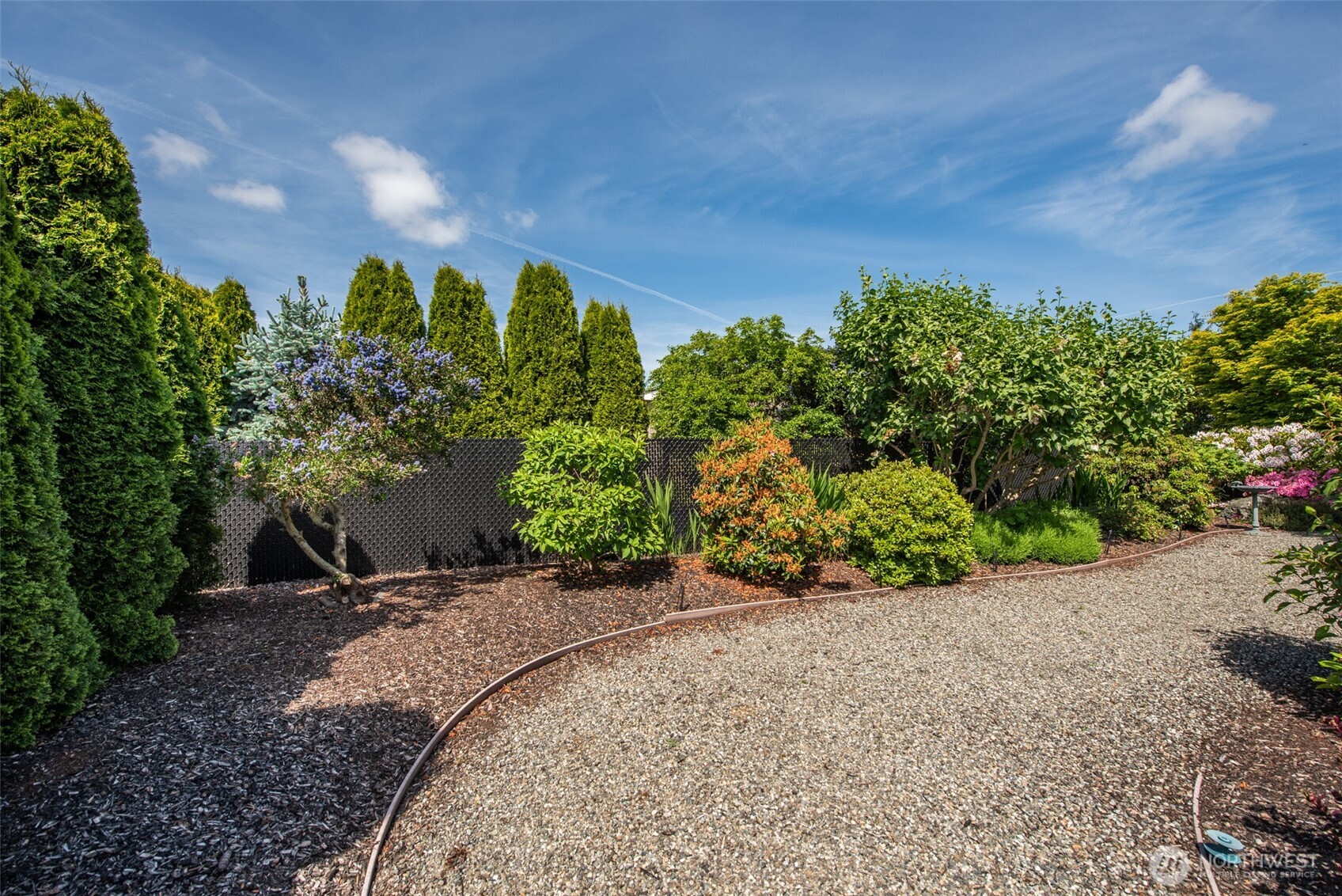 720 West Heritage Loop Sequim, WA 98382 - Photo 6 of 35 a view of a garden with plants and a bench