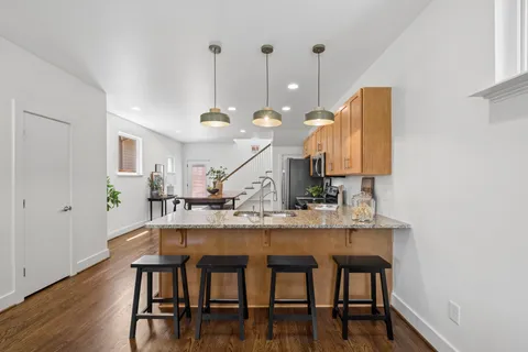 a kitchen with stainless steel appliances granite countertop a sink stove and refrigerator