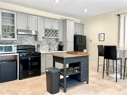 a kitchen with granite countertop a stove top oven and cabinets