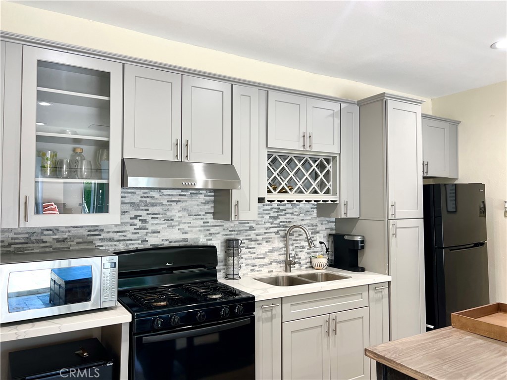 17401 Raymer Street Northridge, CA 91325 - Photo 7 of 19 a kitchen with a stove and a refrigerator