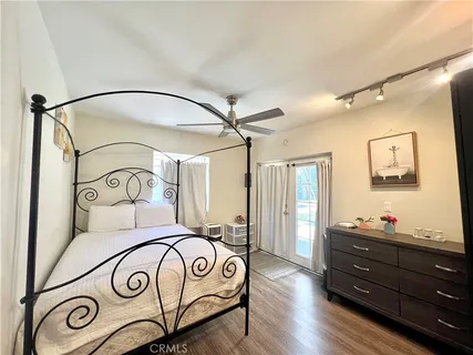 a bedroom with a bed and a mirror on the dresser