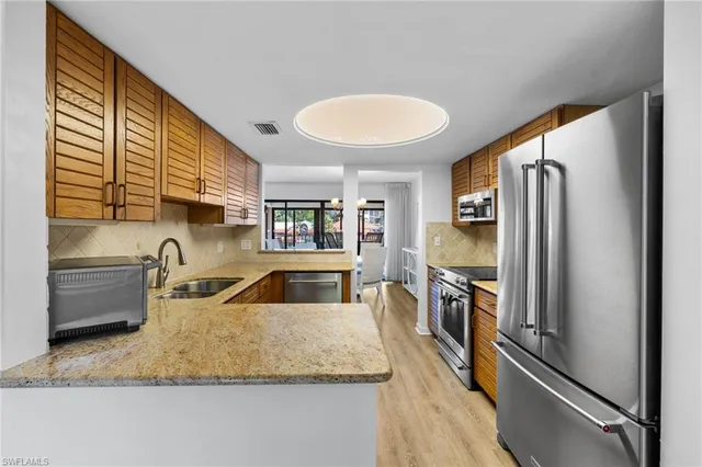 a kitchen with stainless steel appliances granite countertop a sink refrigerator and cabinets