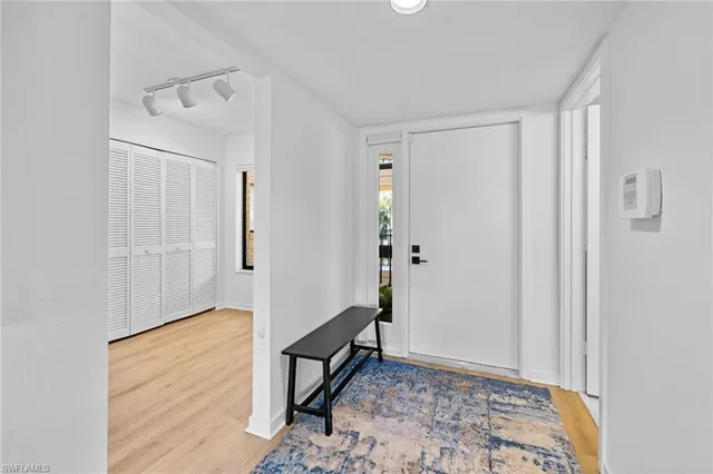 a view of a hallway with wooden floor and a livingroom
