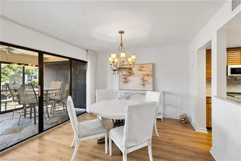 a dining room with furniture a chandelier and wooden floor