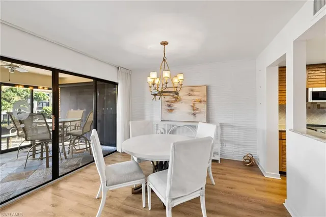 a dining room with furniture a chandelier and wooden floor