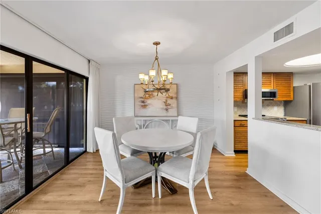 a dining room with furniture a chandelier and wooden floor