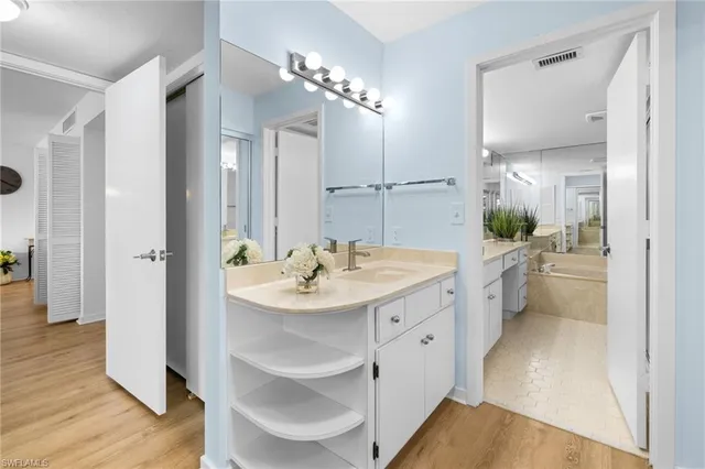 a spacious bathroom with a shower sink and mirror