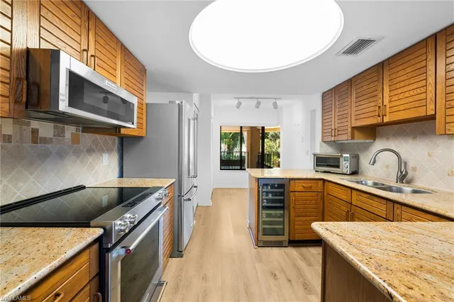 a kitchen with stainless steel appliances granite countertop a sink and stove