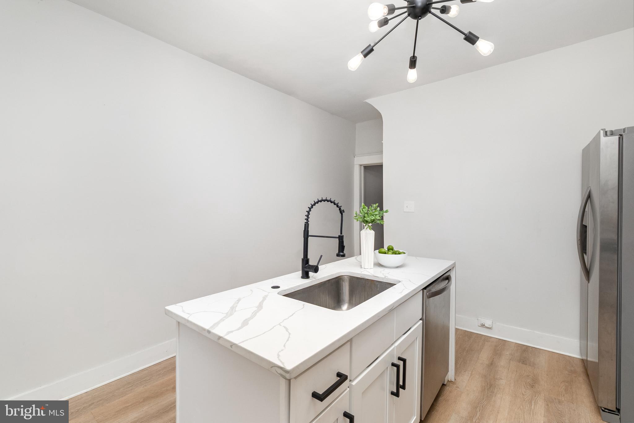 3822 6th Street Baltimore, MD 21225 - Photo 11 of 26 a view of kitchen island with sink and wooden floor