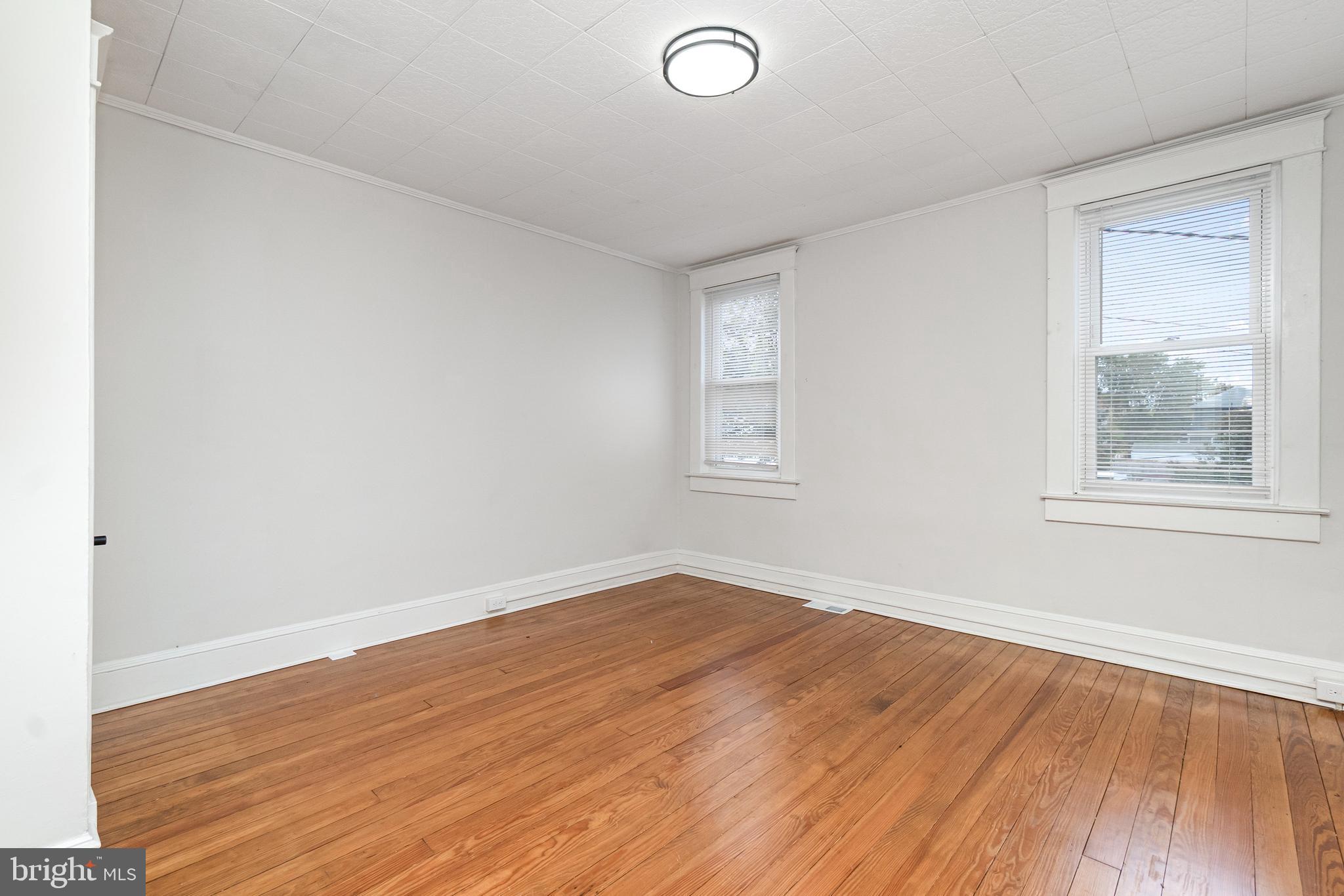 3822 6th Street Baltimore, MD 21225 - Photo 13 of 26 an empty room with wooden floor and windows