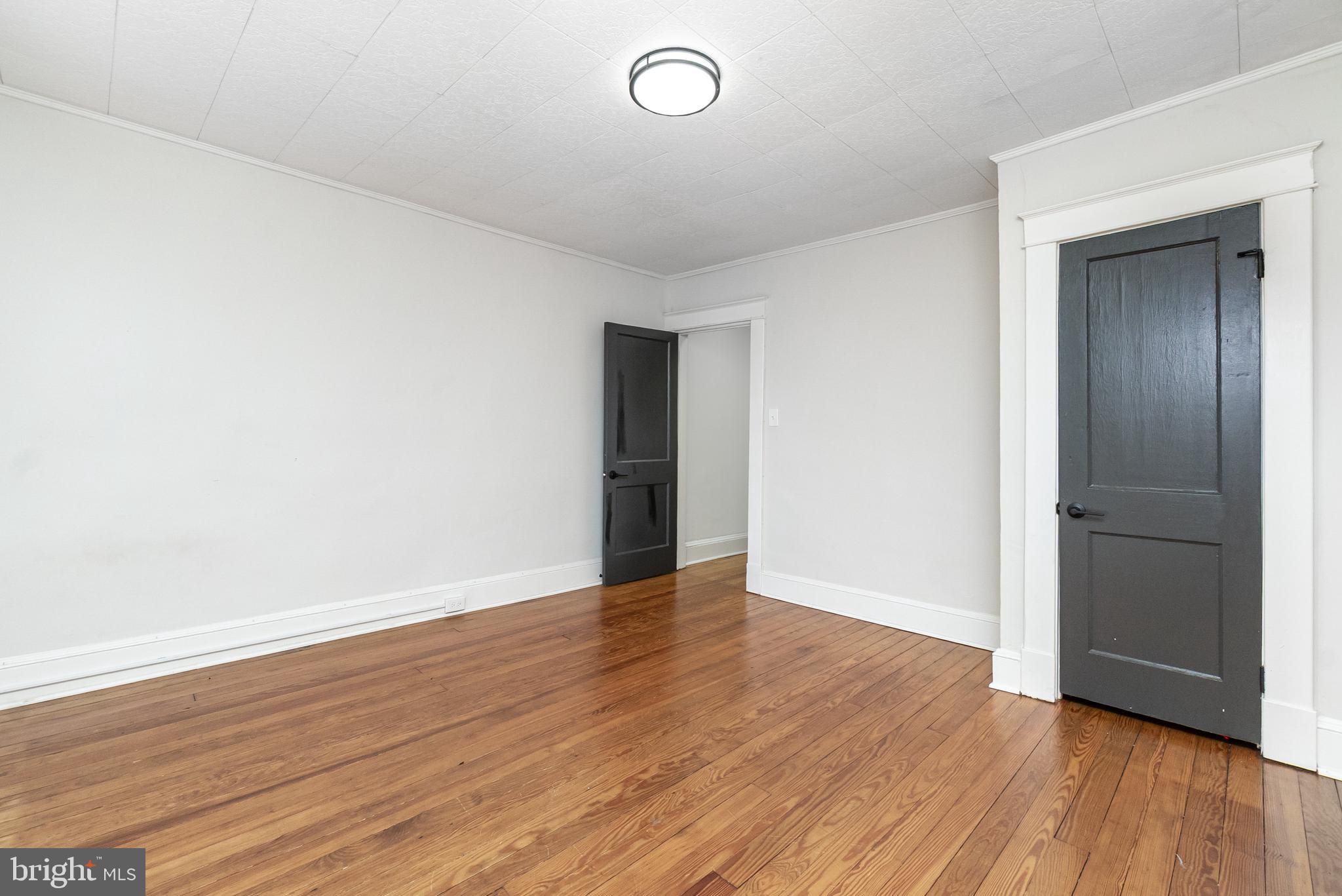 3822 6th Street Baltimore, MD 21225 - Photo 14 of 26 an empty room with wooden floor and windows