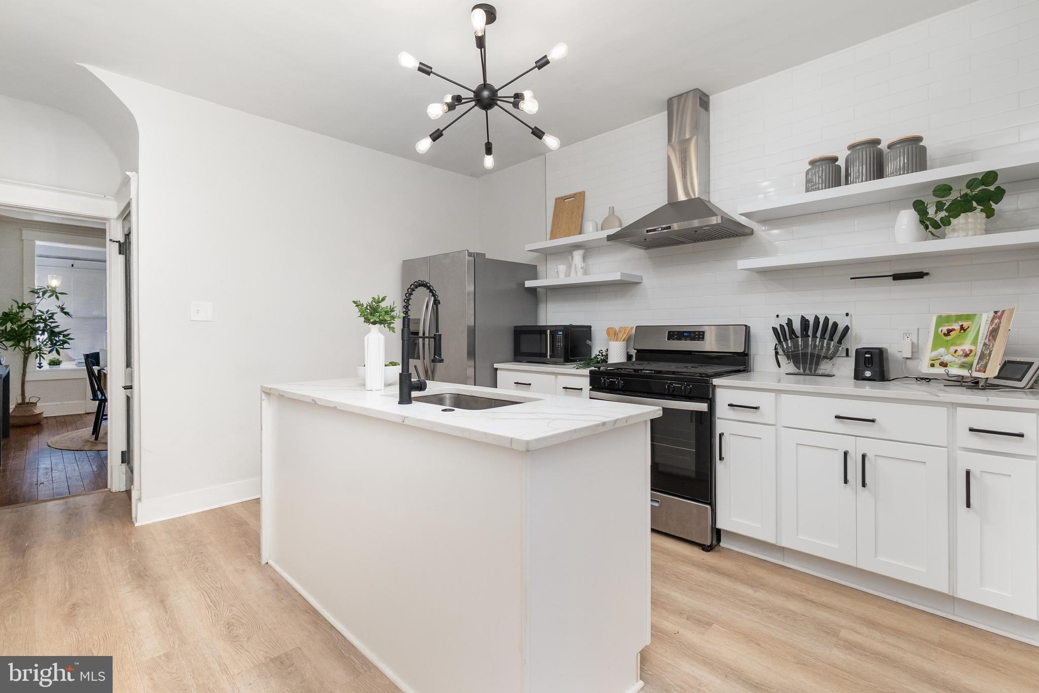 3822 6th Street Baltimore, MD 21225 - Photo 8 of 26 a kitchen with stainless steel appliances a sink a stove and cabinets
