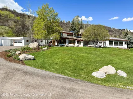 a kitchen with stainless steel appliances granite countertop a stove a sink and a dining table with wooden floor