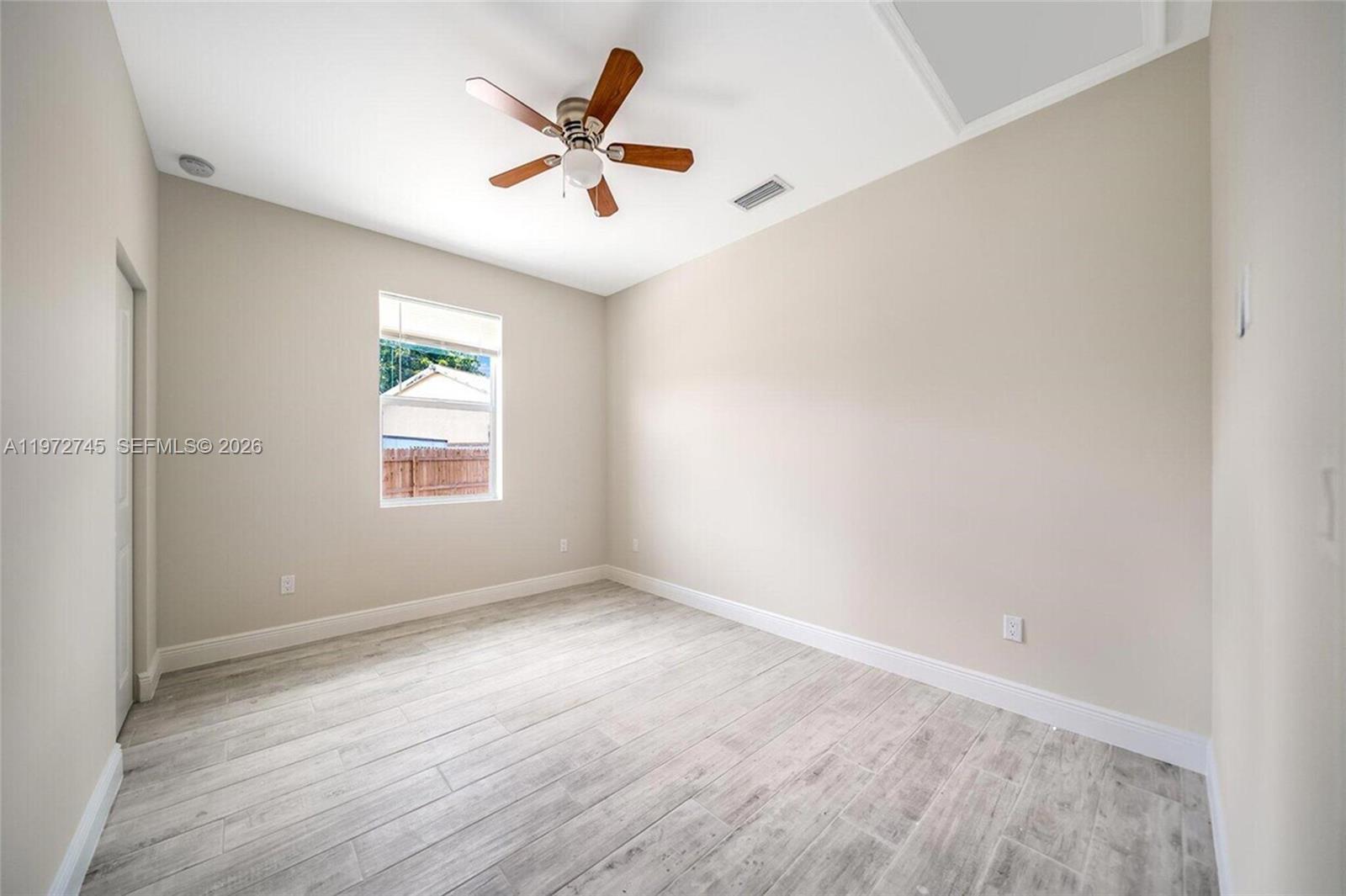 1538 West 26th Court Riviera Beach, FL 33404 - Photo 4 of 13 an empty room with a window and a ceiling fan