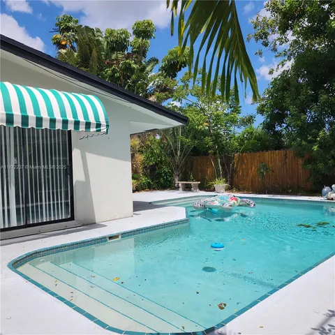 a view of backyard with swimming pool and outdoor seating