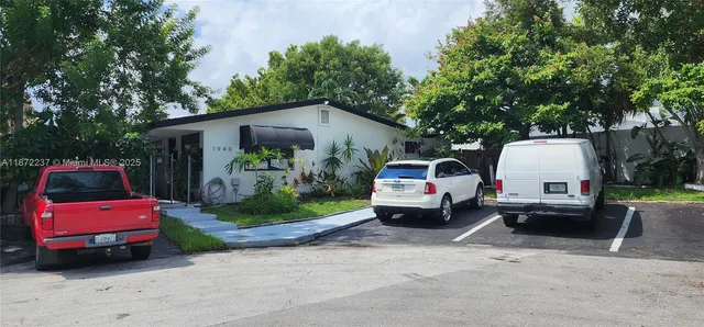 a front view of a house with a garden and parking space