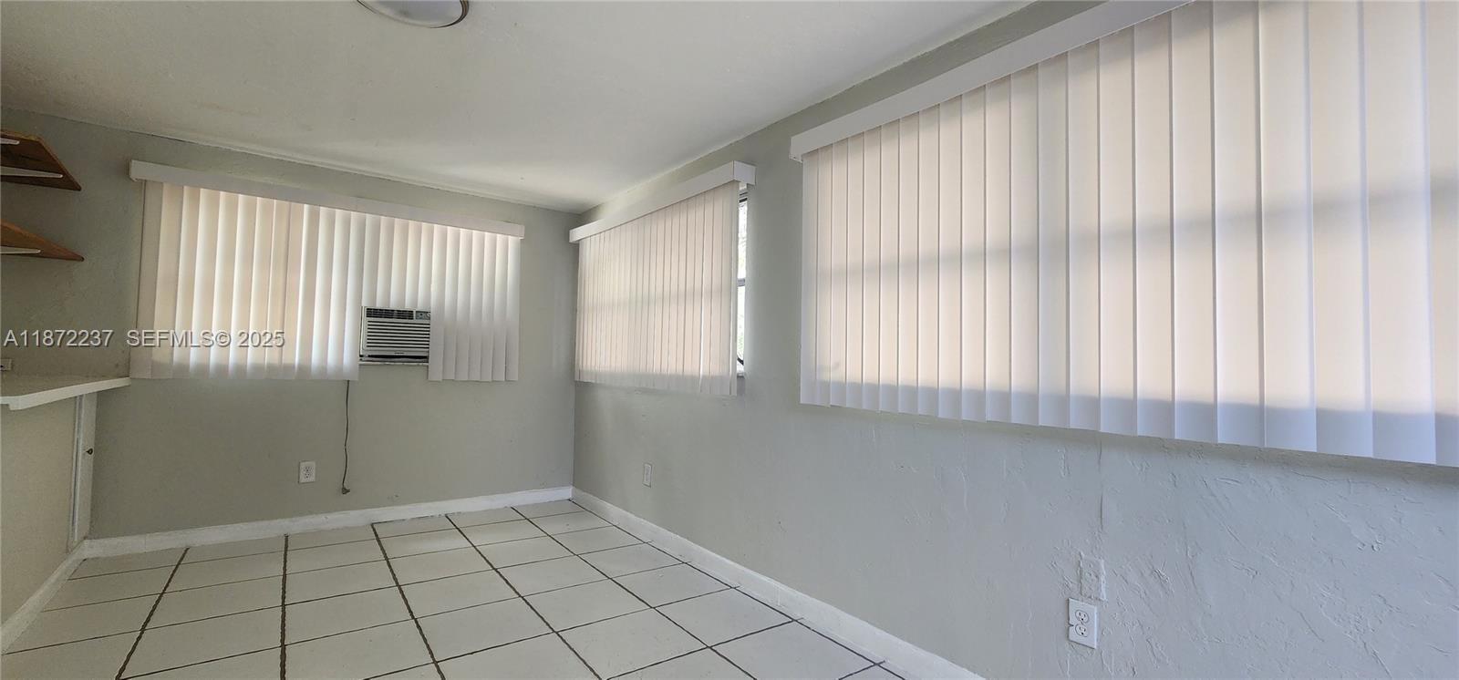 1940 Northeast 31st Court, Unit SOUTH Lighthouse Point, FL 33064 - Photo 23 of 45 a view of an empty room with window and cabinet area
