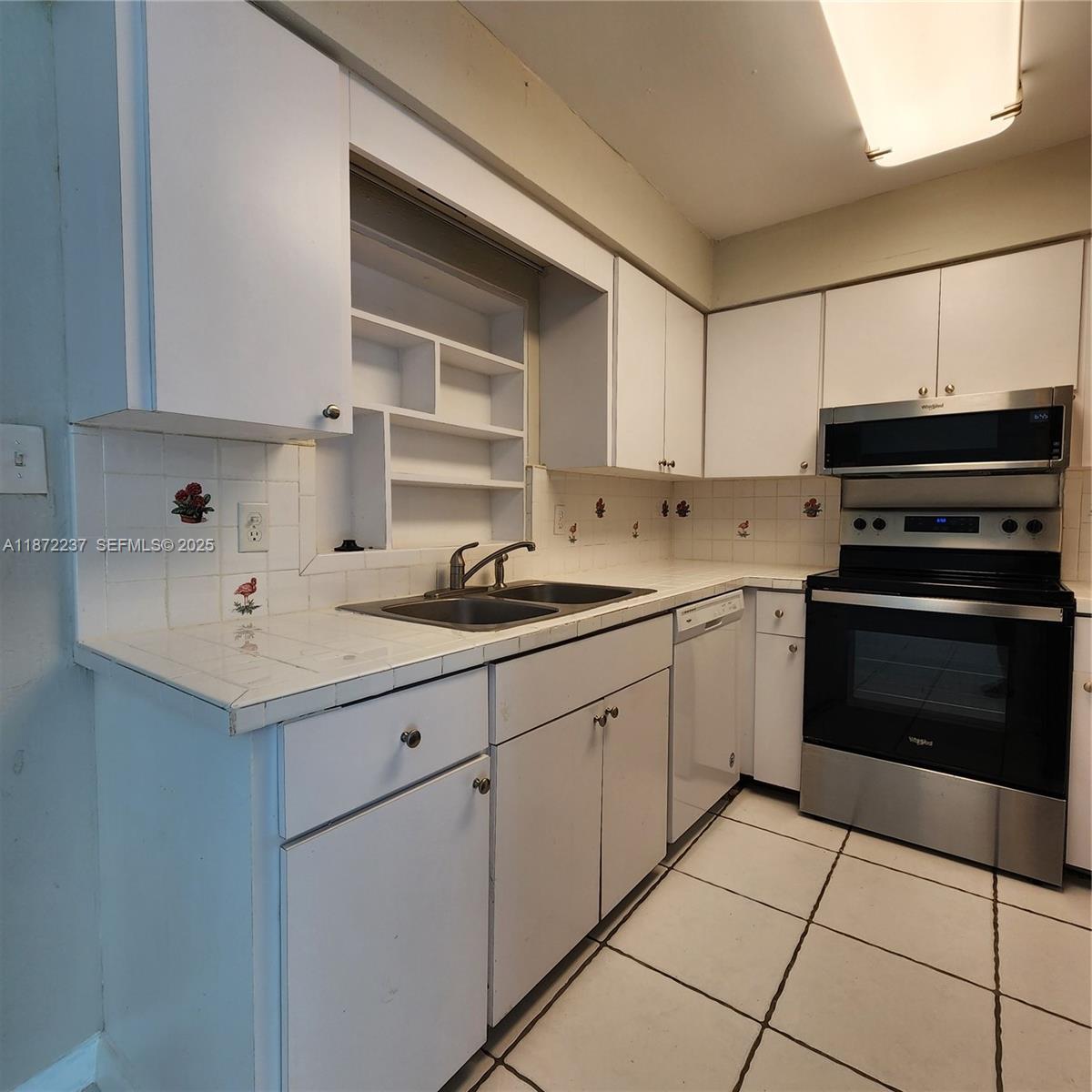 1940 Northeast 31st Court, Unit SOUTH Lighthouse Point, FL 33064 - Photo 26 of 45 a kitchen with a sink cabinets and appliances