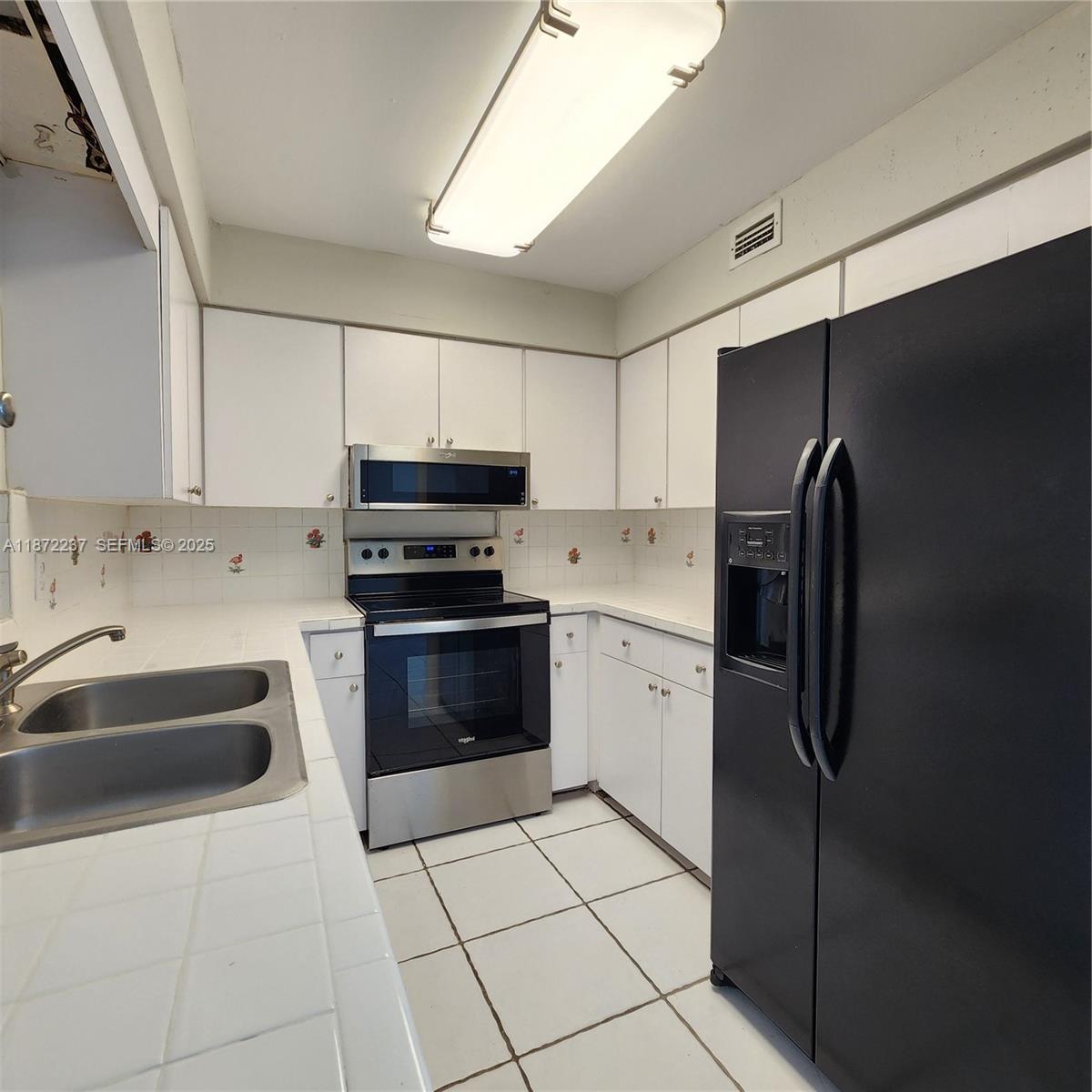 1940 Northeast 31st Court, Unit SOUTH Lighthouse Point, FL 33064 - Photo 27 of 45 a kitchen with stainless steel appliances granite countertop a refrigerator and a sink
