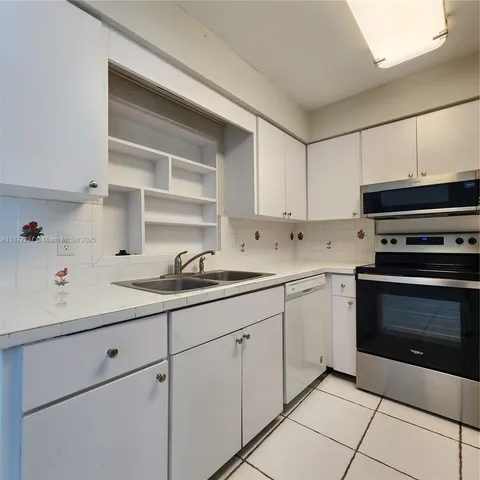 a kitchen with cabinets appliances and a sink