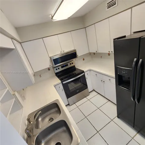 a kitchen with a refrigerator and a stove top oven