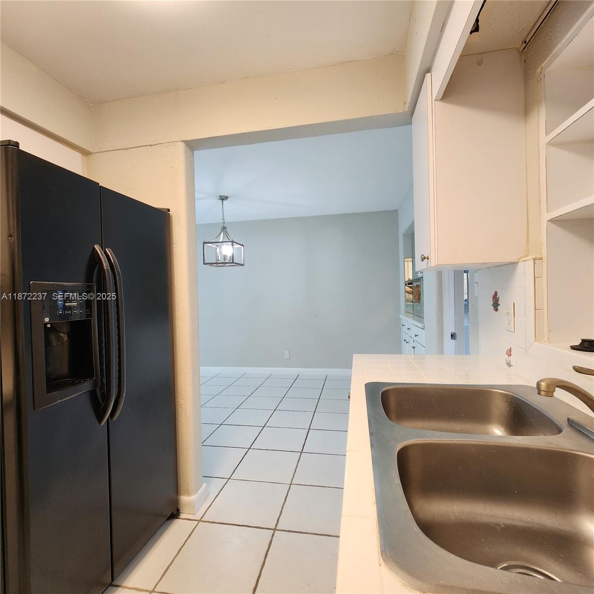 1940 Northeast 31st Court, Unit SOUTH Lighthouse Point, FL 33064 - Photo 31 of 45 a kitchen with a refrigerator a sink and a counter top space