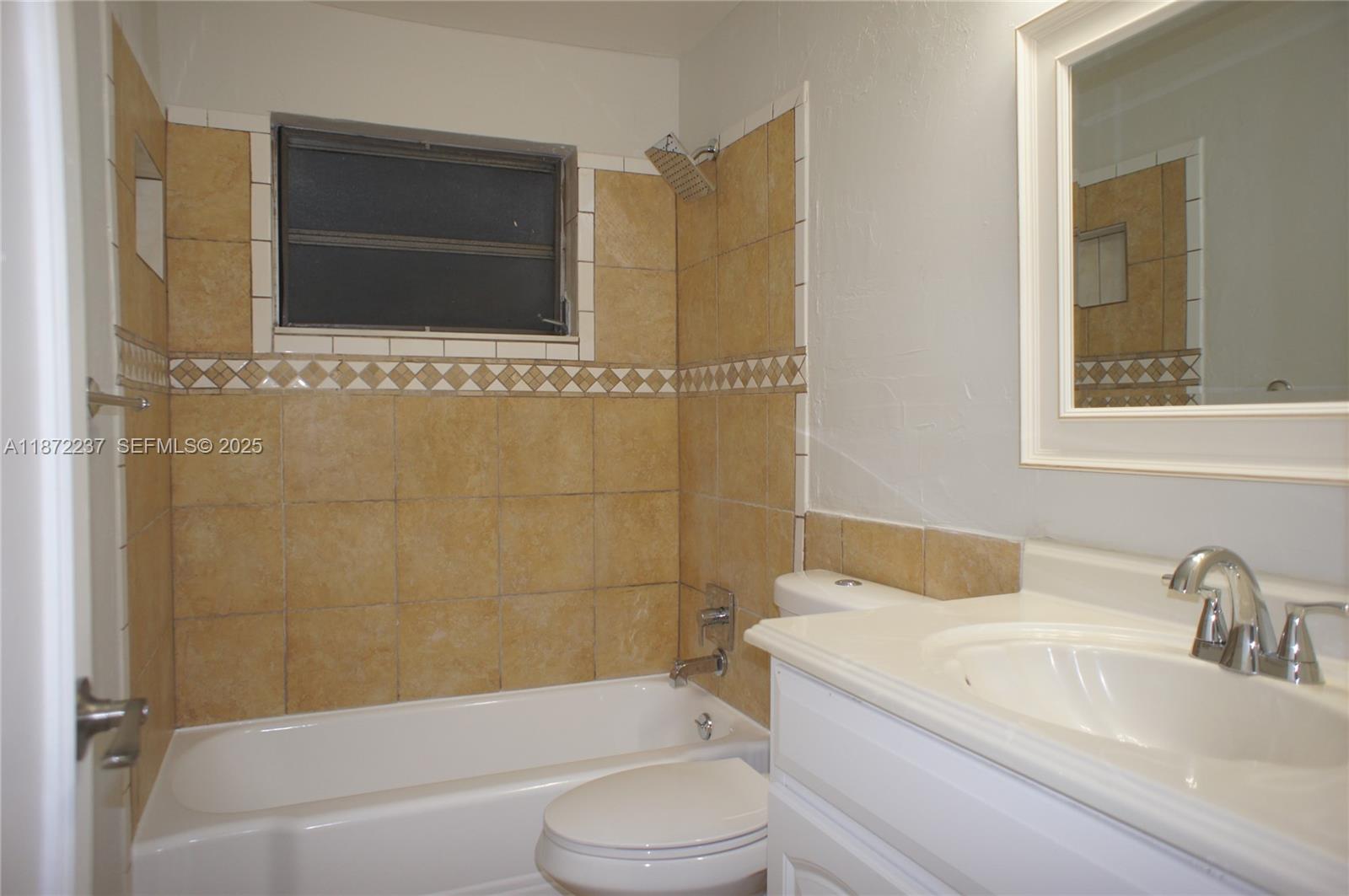 1940 Northeast 31st Court, Unit SOUTH Lighthouse Point, FL 33064 - Photo 41 of 45 a bathroom with a toilet a sink and bathtub