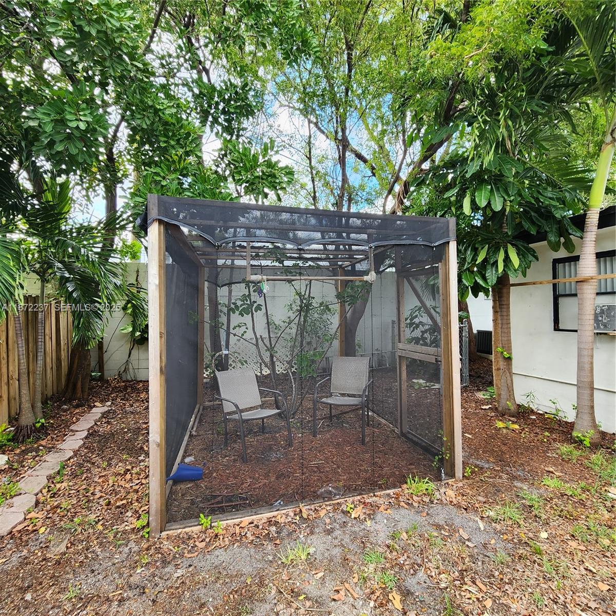 1940 Northeast 31st Court, Unit SOUTH Lighthouse Point, FL 33064 - Photo 8 of 45 a view of a patio with table and chairs a barbeque with a large tree