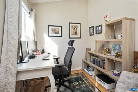 a view of a workspace with furniture and a window