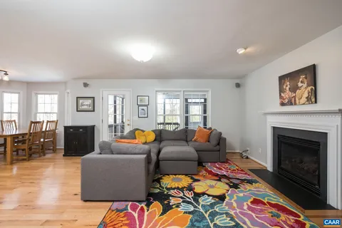 a living room with furniture a fireplace and wooden floor