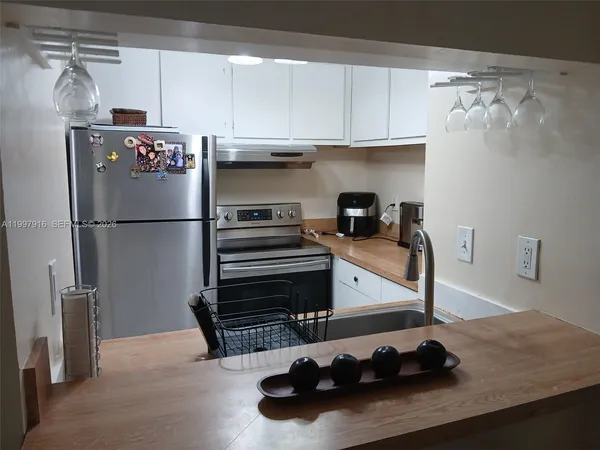 a kitchen with refrigerator and cabinets