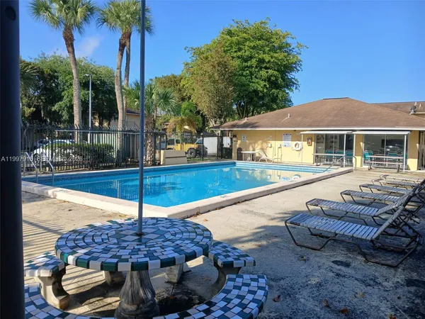 a view of a patio with a table chairs and a fire pit