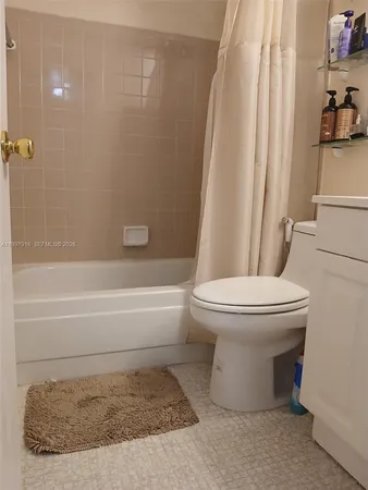 a bathroom with a toilet and a shower curtain