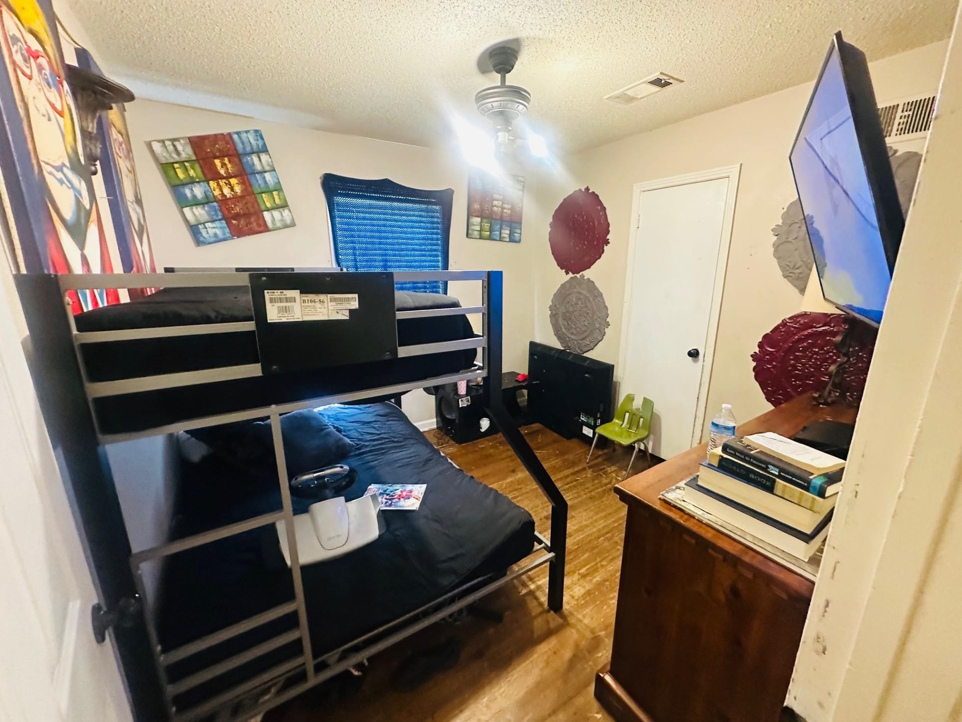 4775 Stacey Road Memphis, TN 38109 - Photo 9 of 13 Bedroom featuring a textured ceiling and wood finished floors