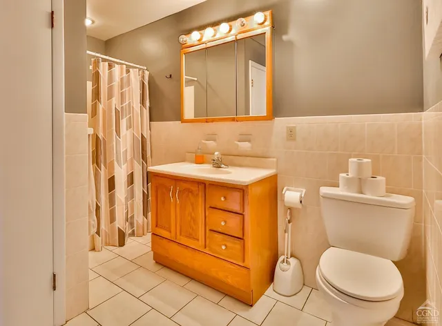 a bathroom with a granite countertop toilet sink and mirror