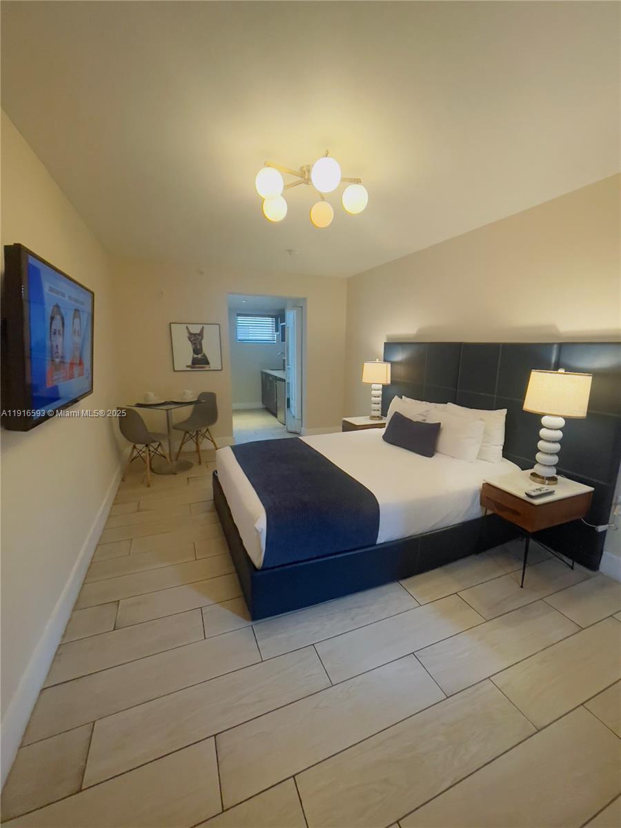 7310 Harding Avenue, Unit 318 Miami Beach, FL 33141 - Photo 4 of 6 a bedroom with a bed and window