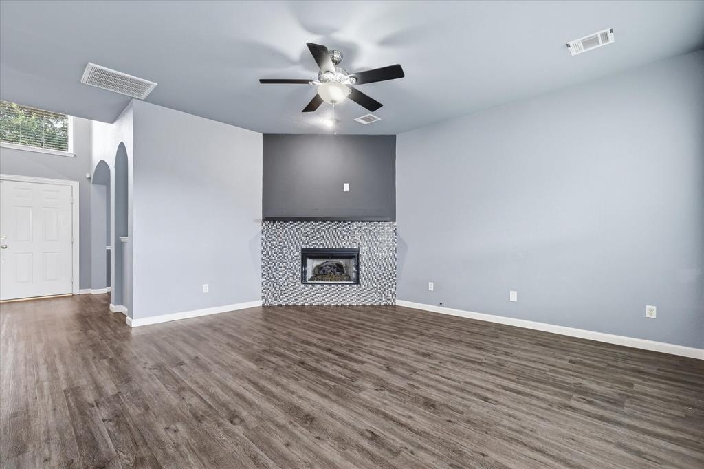 4545 Ridgepointe Drive The Colony, TX 75056 - Photo 9 of 37 Living area featuring wood-finish flooring, a contemporary fireplace with patterned tile surround, and a ceiling fan