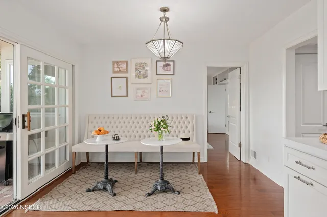 a kitchen with stainless steel appliances a table chairs refrigerator and microwave