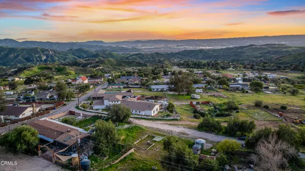 an aerial view of residential houses with outdoor space and trees