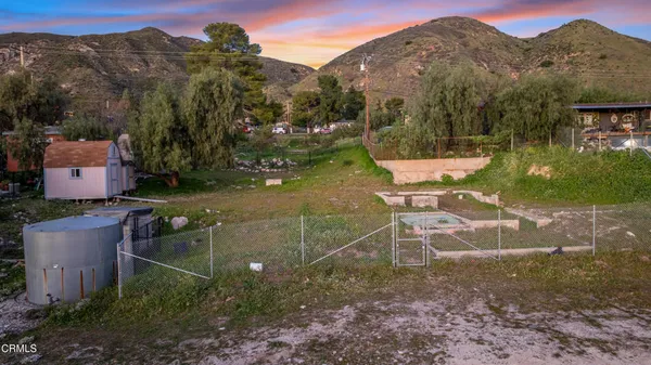 an aerial view of a house with a yard and mountain view