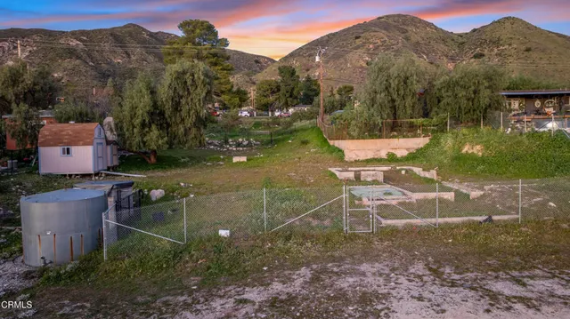 an aerial view of a house with a yard and mountain view