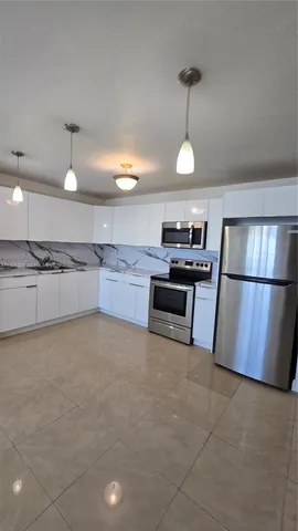 a kitchen with refrigerator and microwave