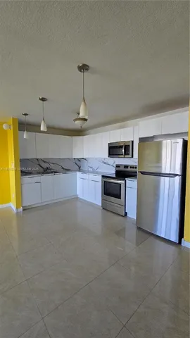 a kitchen with stainless steel appliances granite countertop a refrigerator and a stove
