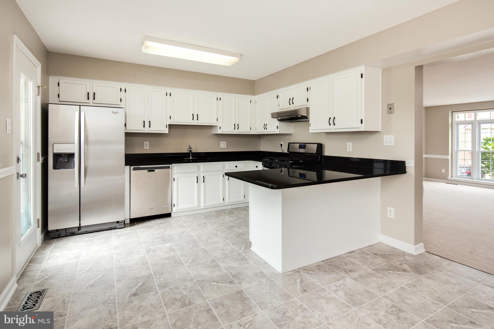 46871 Rabbitrun Terrace Sterling, VA 20164 - Photo 7 of 30 a kitchen with a refrigerator a stove and white cabinets