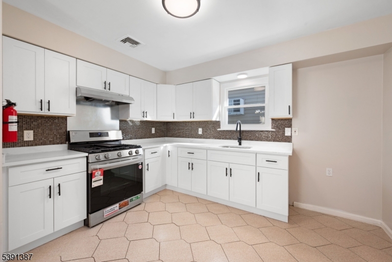 566 2nd Avenue Elizabeth, NJ 07202 - Photo 25 of 38 a kitchen with granite countertop white cabinets white stainless steel appliances with a sink and dishwasher