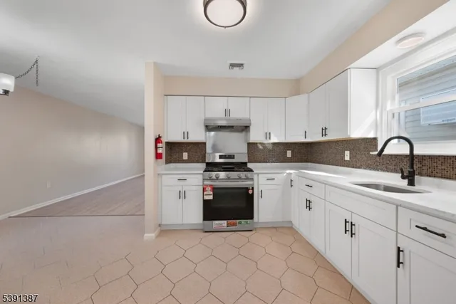 a kitchen with white cabinets and appliances