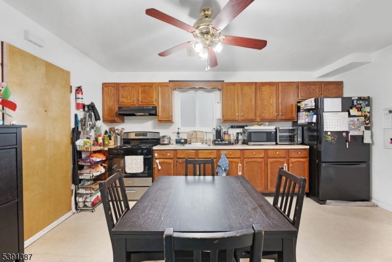 566 2nd Avenue Elizabeth, NJ 07202 - Photo 8 of 38 a kitchen with stainless steel appliances granite countertop a stove a refrigerator a kitchen island a dining table and chairs with wooden floor