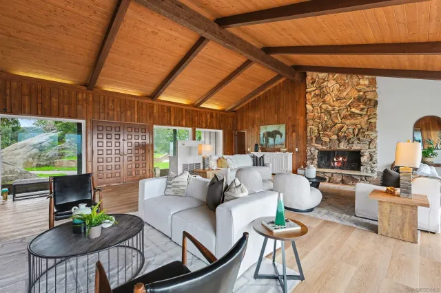a living room with fireplace furniture and a large window