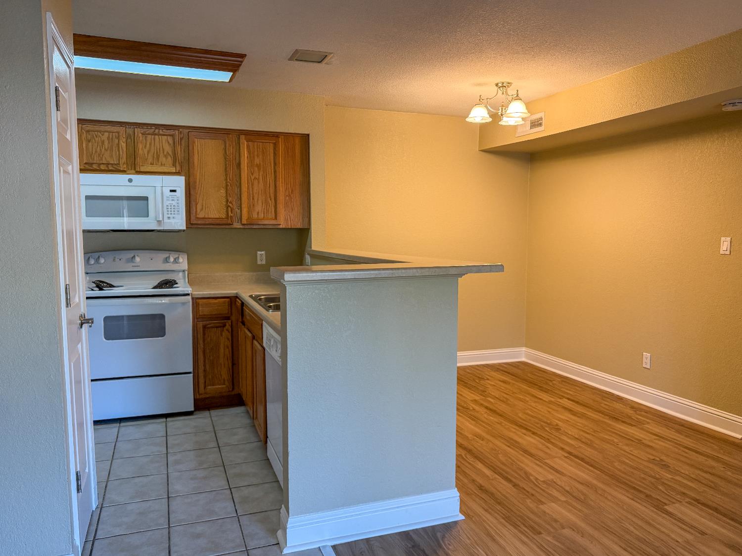 2881 Huntington Boulevard, Unit 150 Fresno, CA 93721 - Photo 3 of 15 a kitchen with stainless steel appliances a sink cabinets and wooden floor