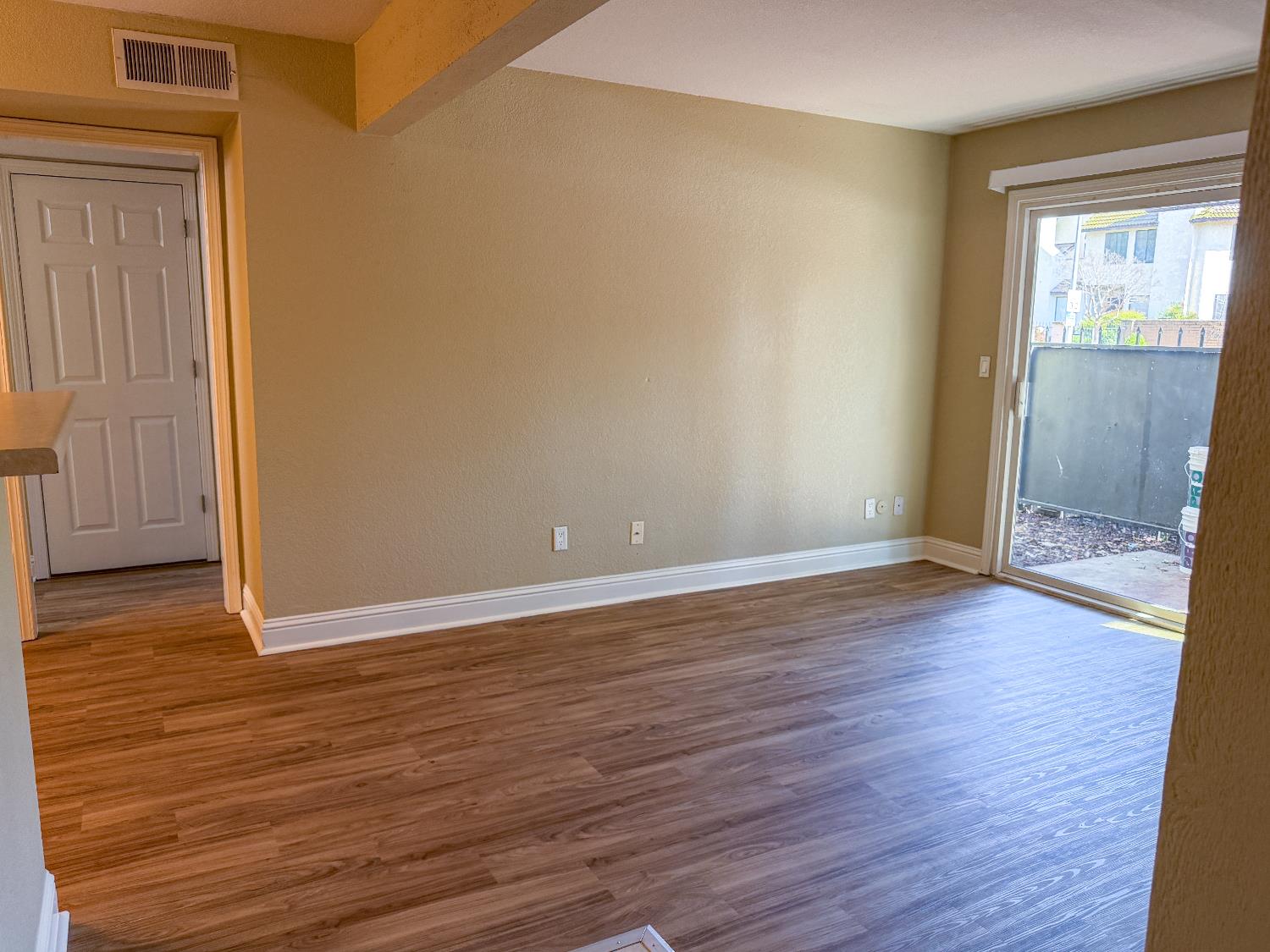 2881 Huntington Boulevard, Unit 150 Fresno, CA 93721 - Photo 4 of 15 a view of an empty room with wooden floor and a window